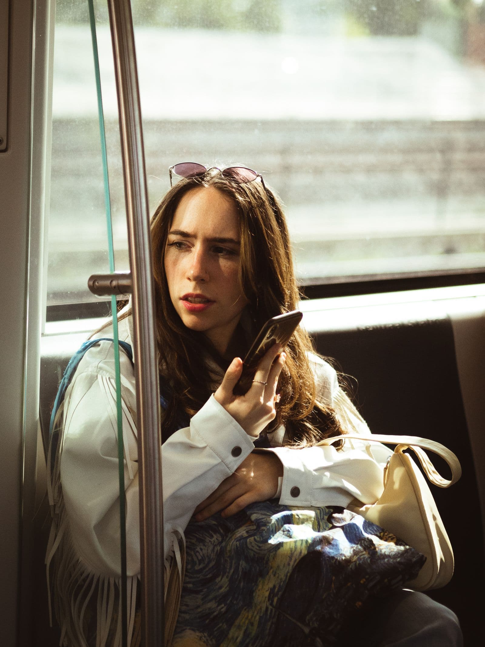 A young woman reading a vacancy on her phone on a tram